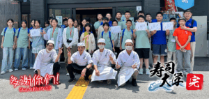 寿司大学を終えた中国の学生とスタッフの集合写真。